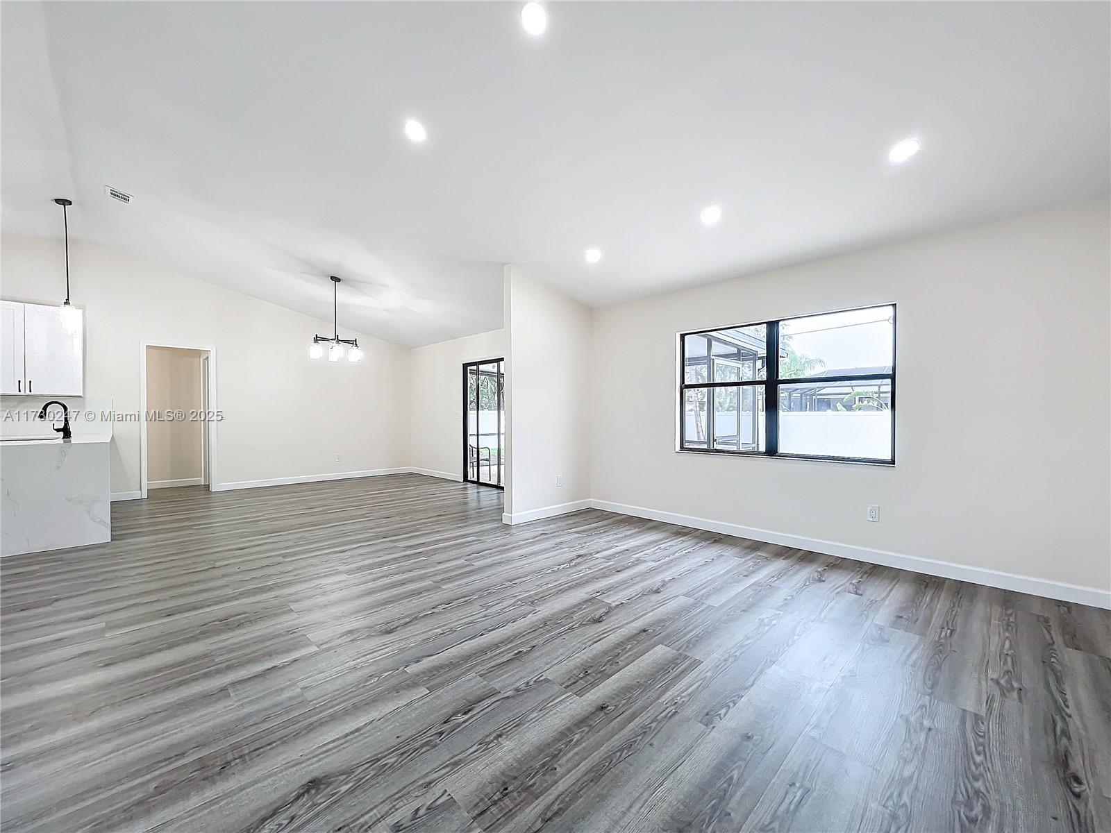 521 Southwest Rabbit Avenue Port St. Lucie, FL 34953 - Photo 18 of 45 a view of an empty room with wooden floor and a window