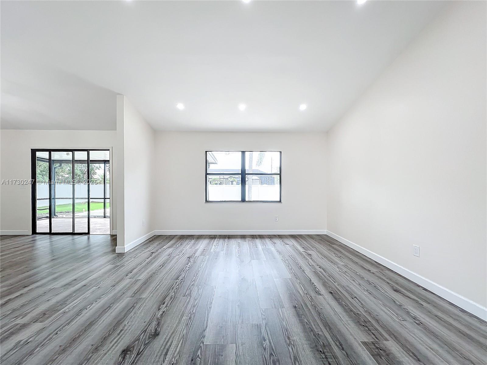521 Southwest Rabbit Avenue Port St. Lucie, FL 34953 - Photo 19 of 45 an empty room with wooden floor and windows