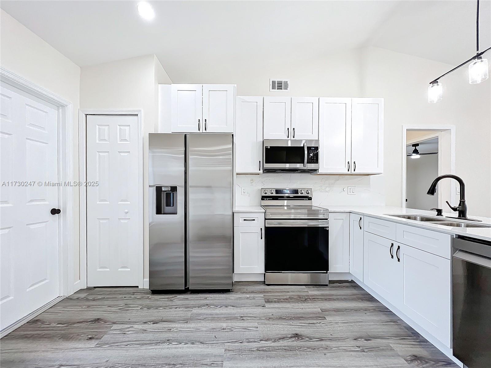 521 Southwest Rabbit Avenue Port St. Lucie, FL 34953 - Photo 21 of 45 a kitchen with stainless steel appliances granite countertop a refrigerator stove and sink