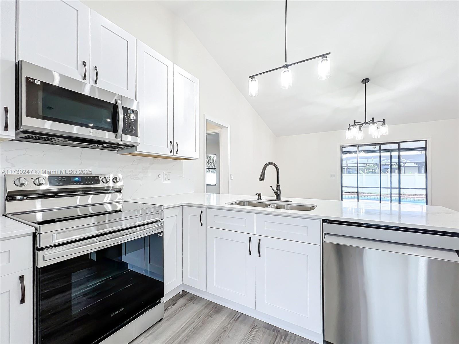 521 Southwest Rabbit Avenue Port St. Lucie, FL 34953 - Photo 22 of 45 a kitchen with stainless steel appliances a stove microwave and sink
