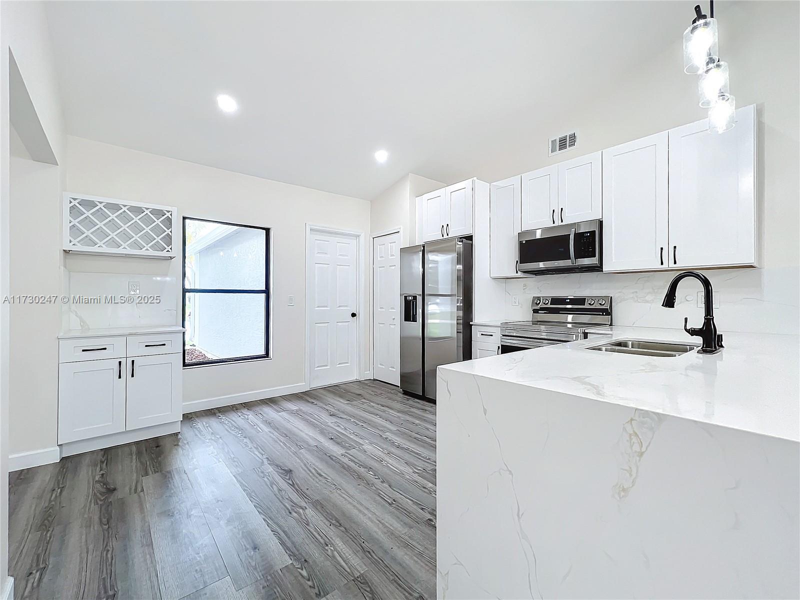 521 Southwest Rabbit Avenue Port St. Lucie, FL 34953 - Photo 23 of 45 a kitchen with stainless steel appliances a refrigerator sink and microwave