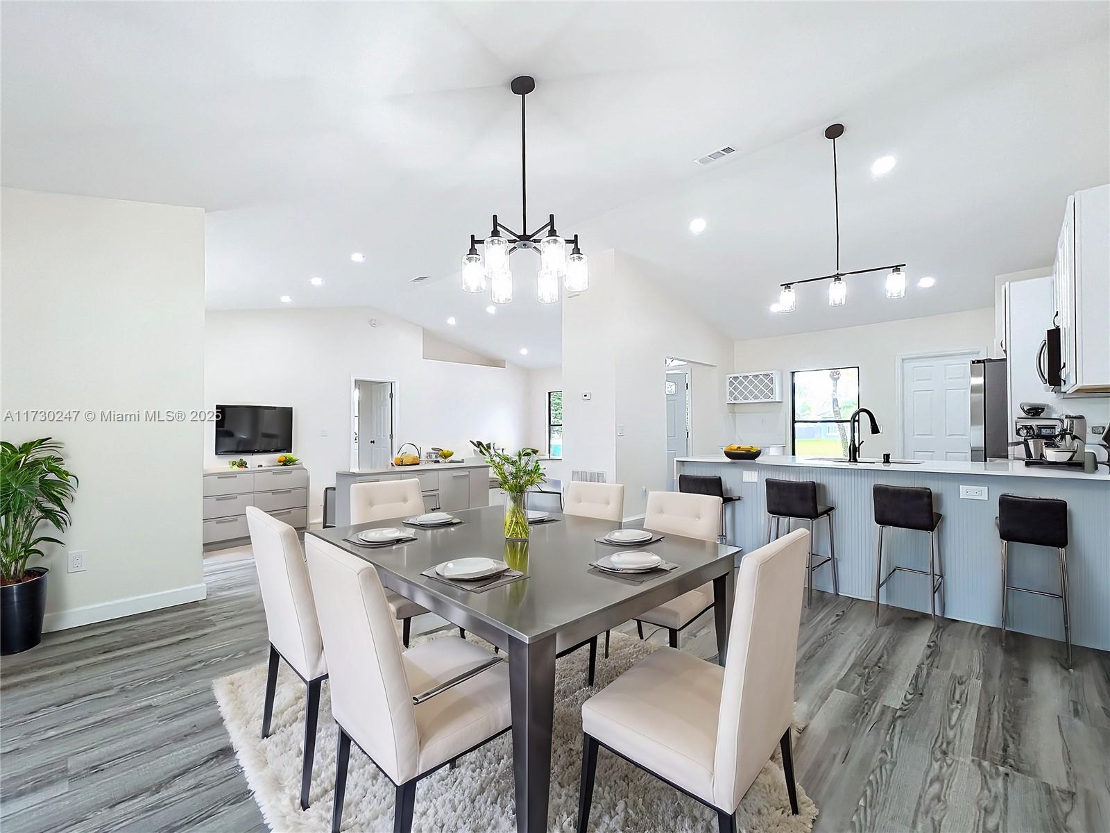521 Southwest Rabbit Avenue Port St. Lucie, FL 34953 - Photo 28 of 45 a view of a dining room and livingroom with furniture wooden floor a rug a potted plant and a chandelier