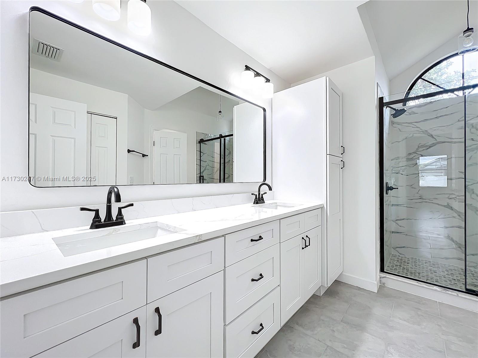 521 Southwest Rabbit Avenue Port St. Lucie, FL 34953 - Photo 34 of 45 a bathroom with double sink and a mirror