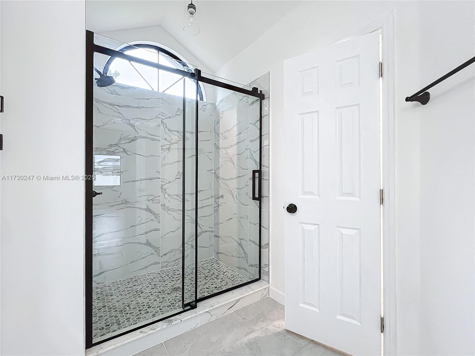 521 Southwest Rabbit Avenue Port St. Lucie, FL 34953 - Photo 35 of 45 a bathroom with a glass shower door