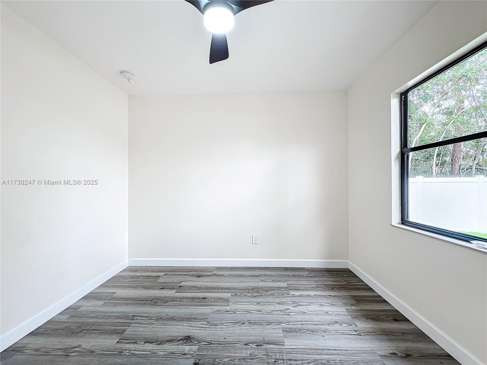 521 Southwest Rabbit Avenue Port St. Lucie, FL 34953 - Photo 37 of 45 a view of an empty room with wooden floor and a window