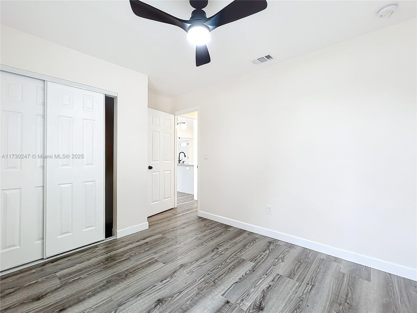 521 Southwest Rabbit Avenue Port St. Lucie, FL 34953 - Photo 39 of 45 an empty room with wooden floor