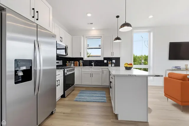 a kitchen with stainless steel appliances a refrigerator sink and microwave
