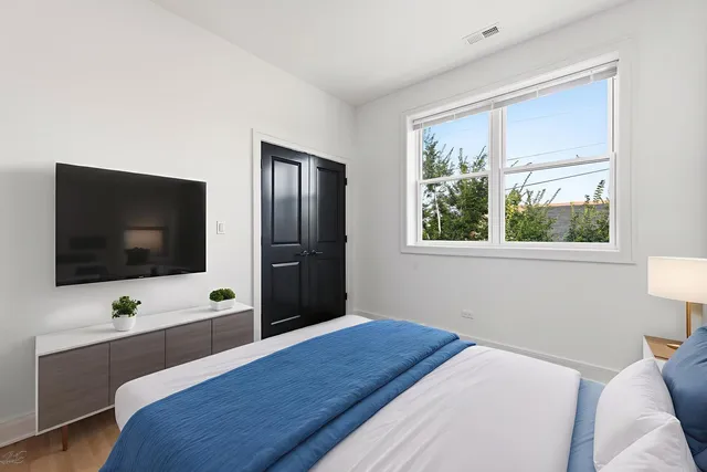 a bedroom with a bed and a flat screen tv