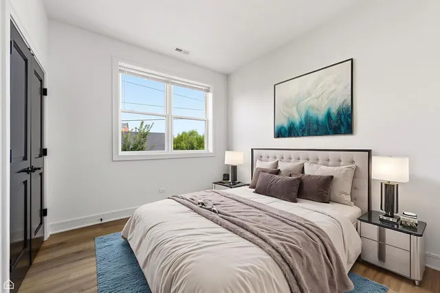 a bedroom with a bed and a painting on the wall