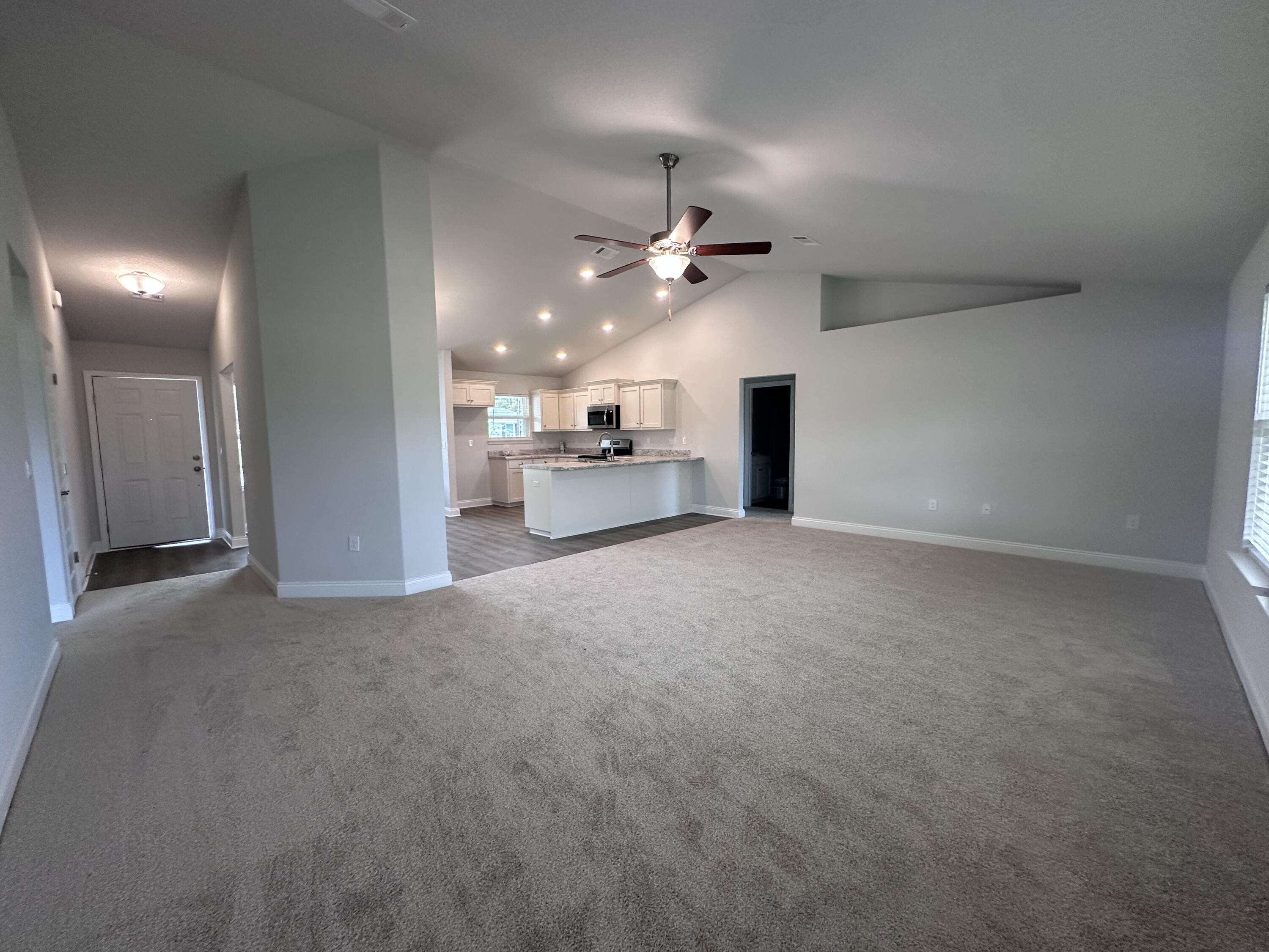 6114 Buckshot Drive Crestview, FL 32539 - Photo 12 of 22 an empty room with a chandelier fan and windows
