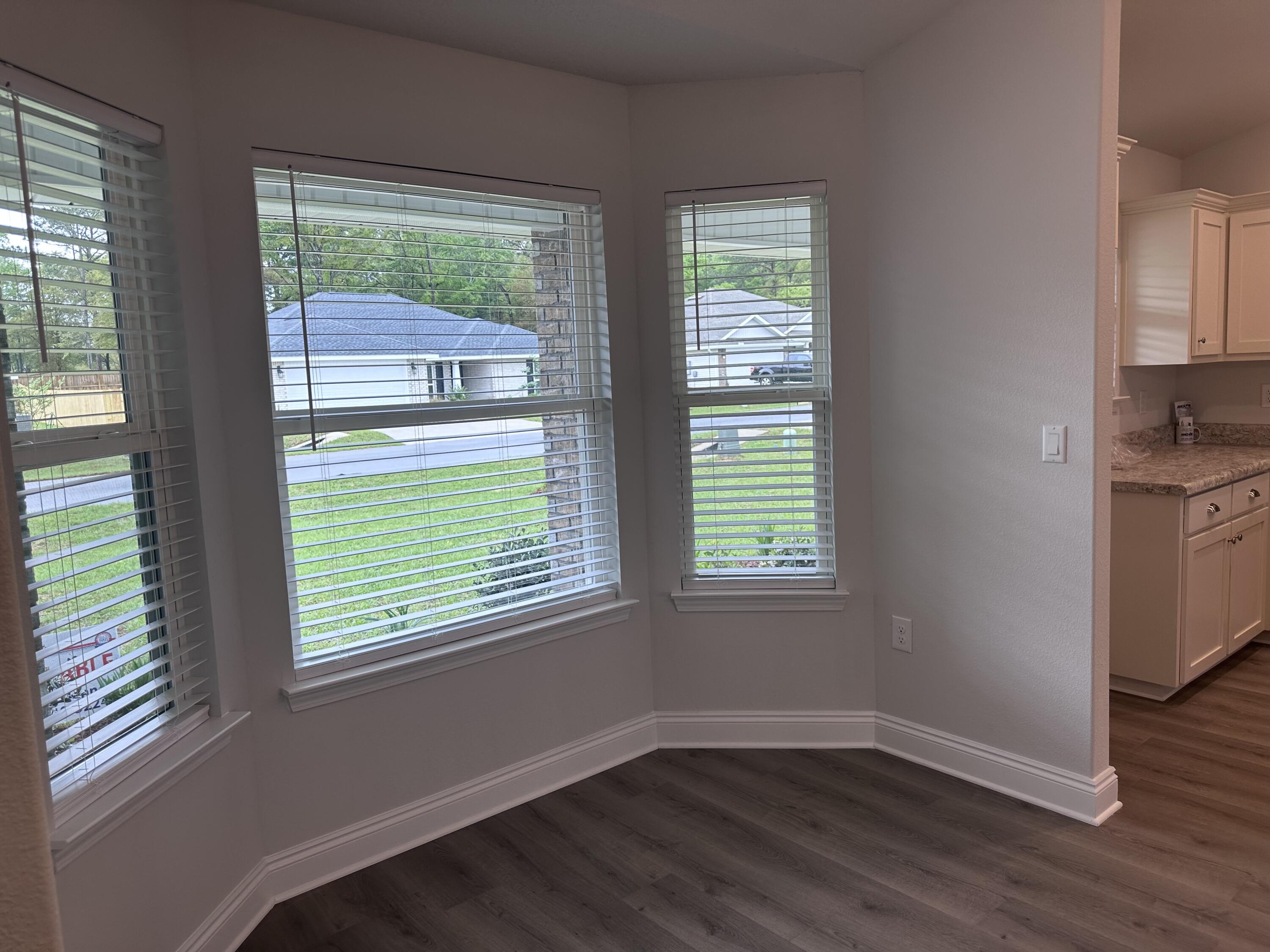 6114 Buckshot Drive Crestview, FL 32539 - Photo 19 of 22 an empty room with wooden floor and windows