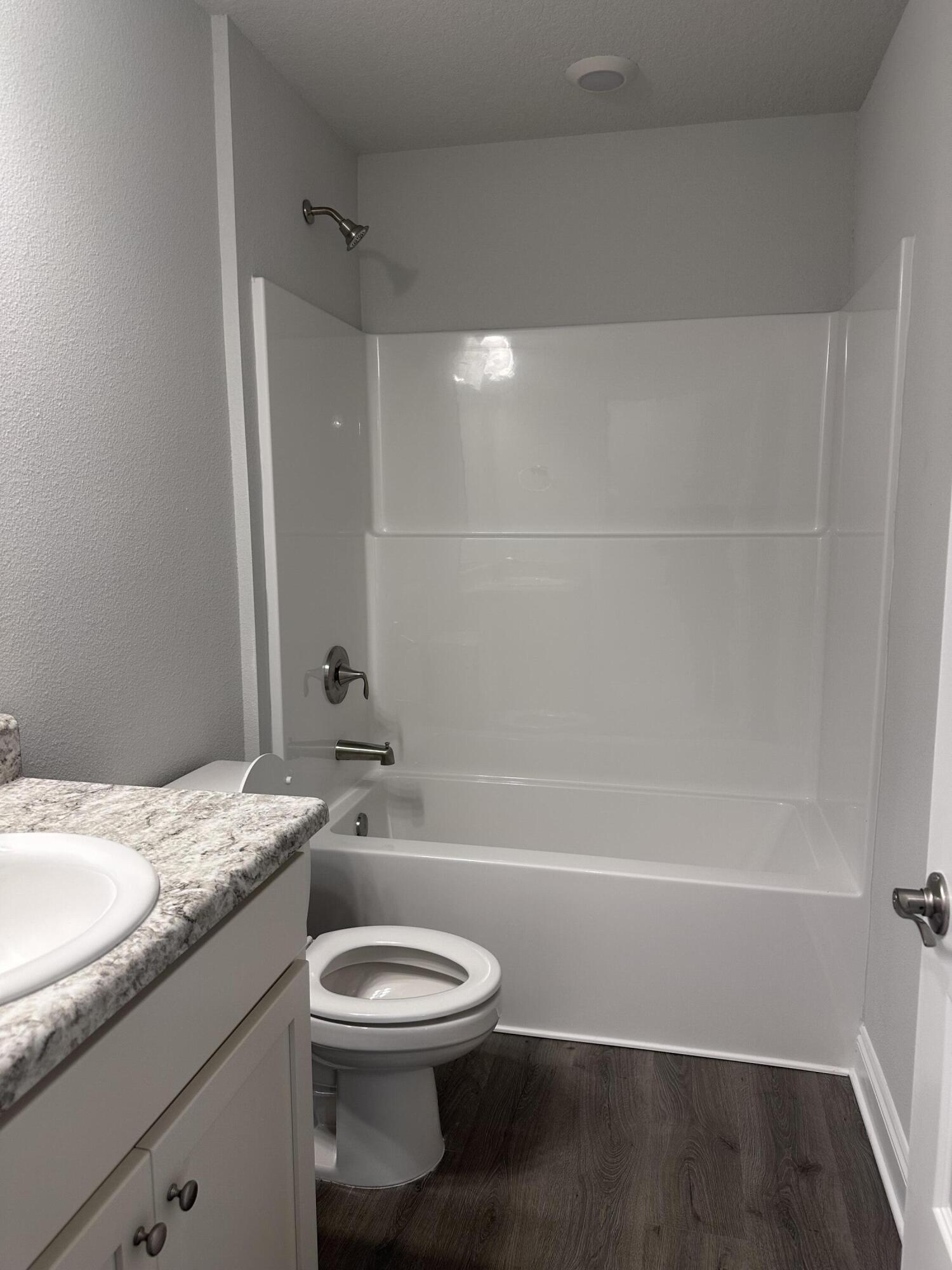 6114 Buckshot Drive Crestview, FL 32539 - Photo 7 of 22 a bathroom with a granite countertop toilet a sink and bathtub