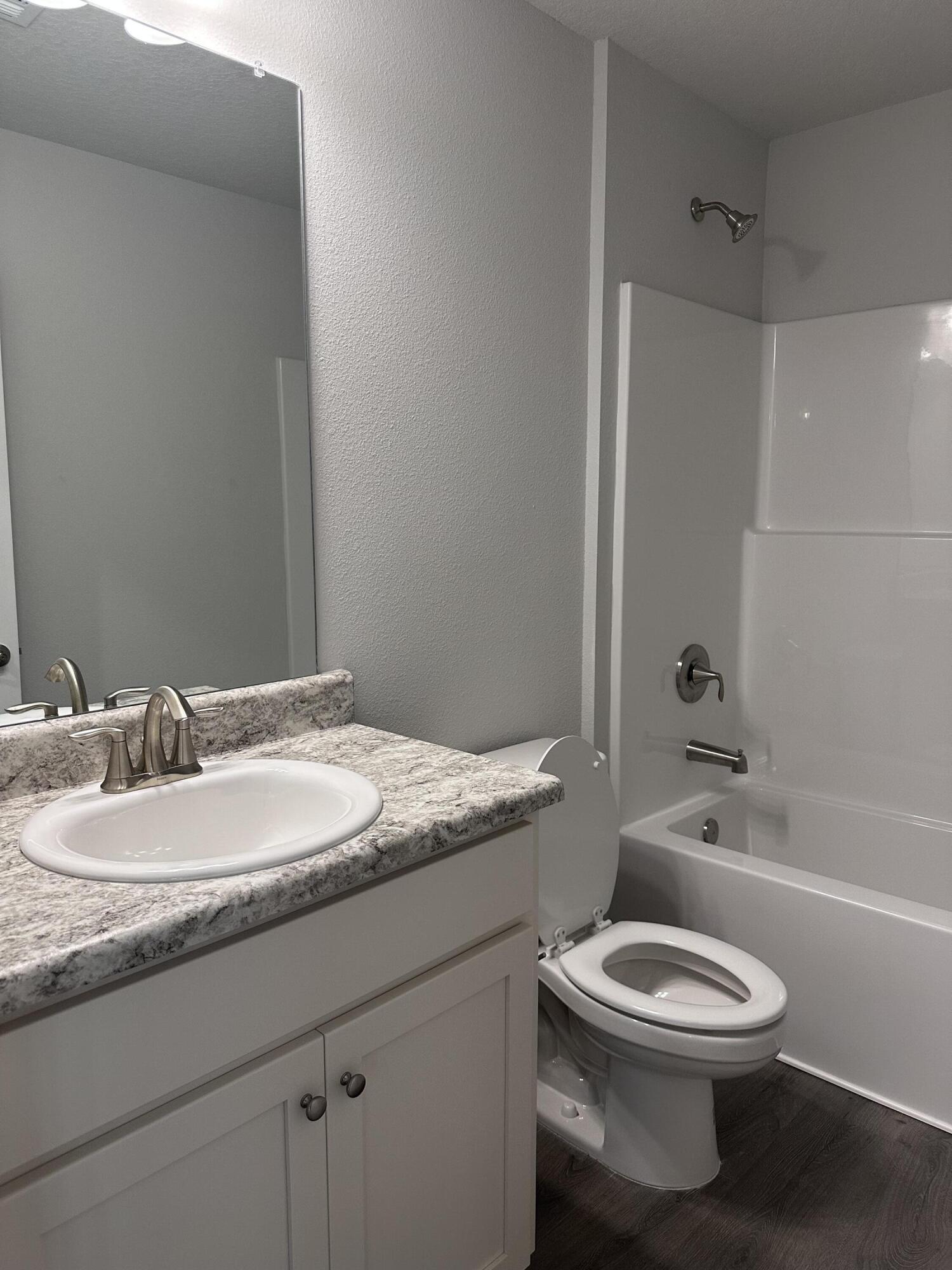 6114 Buckshot Drive Crestview, FL 32539 - Photo 8 of 22 a bathroom with a granite countertop toilet a sink and a bathtub