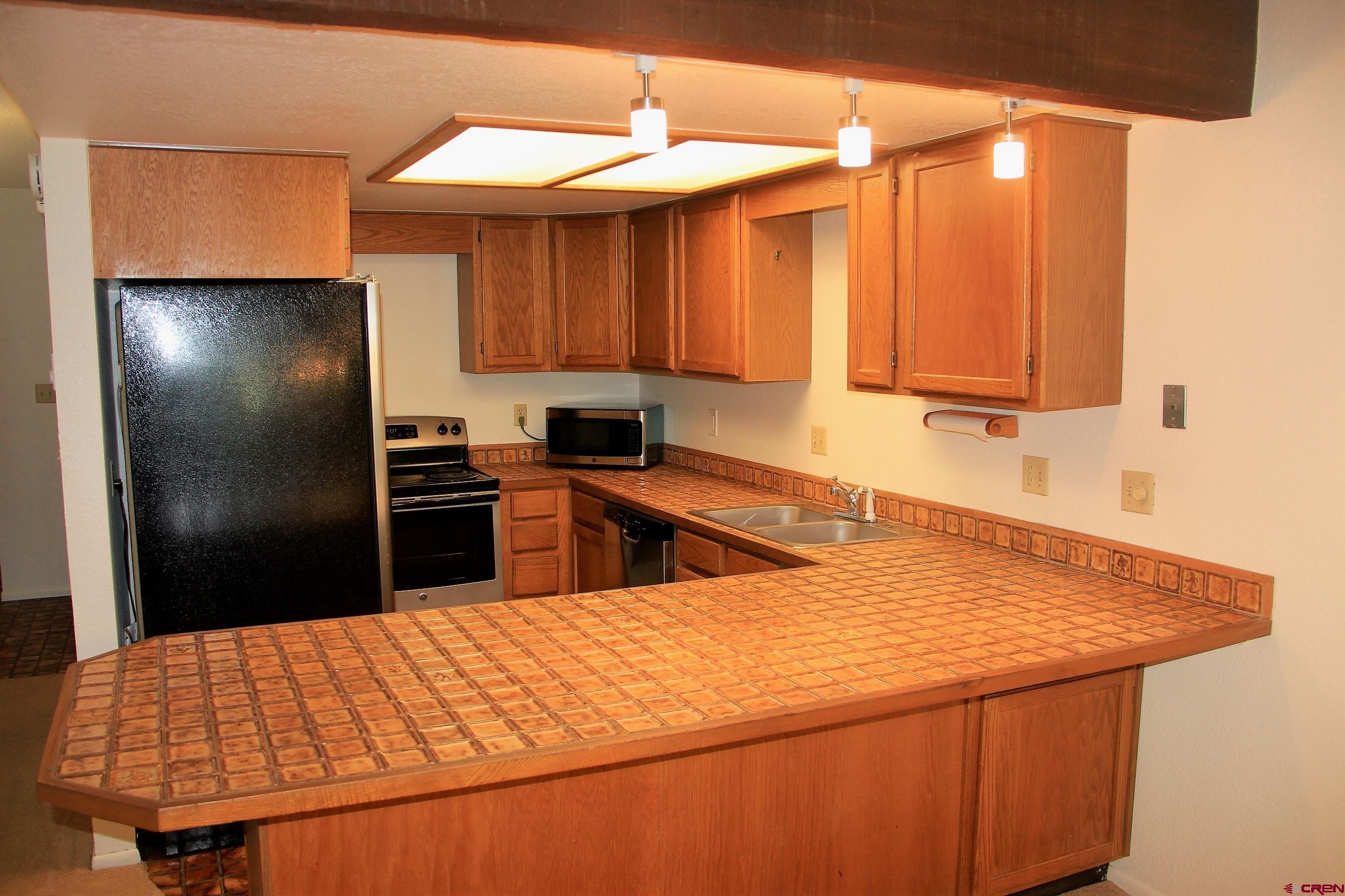 1825 Florida Road, Unit 103 Durango, CO 81301 - Photo 11 of 34 a kitchen with stainless steel appliances kitchen island a refrigerator sink and cabinets