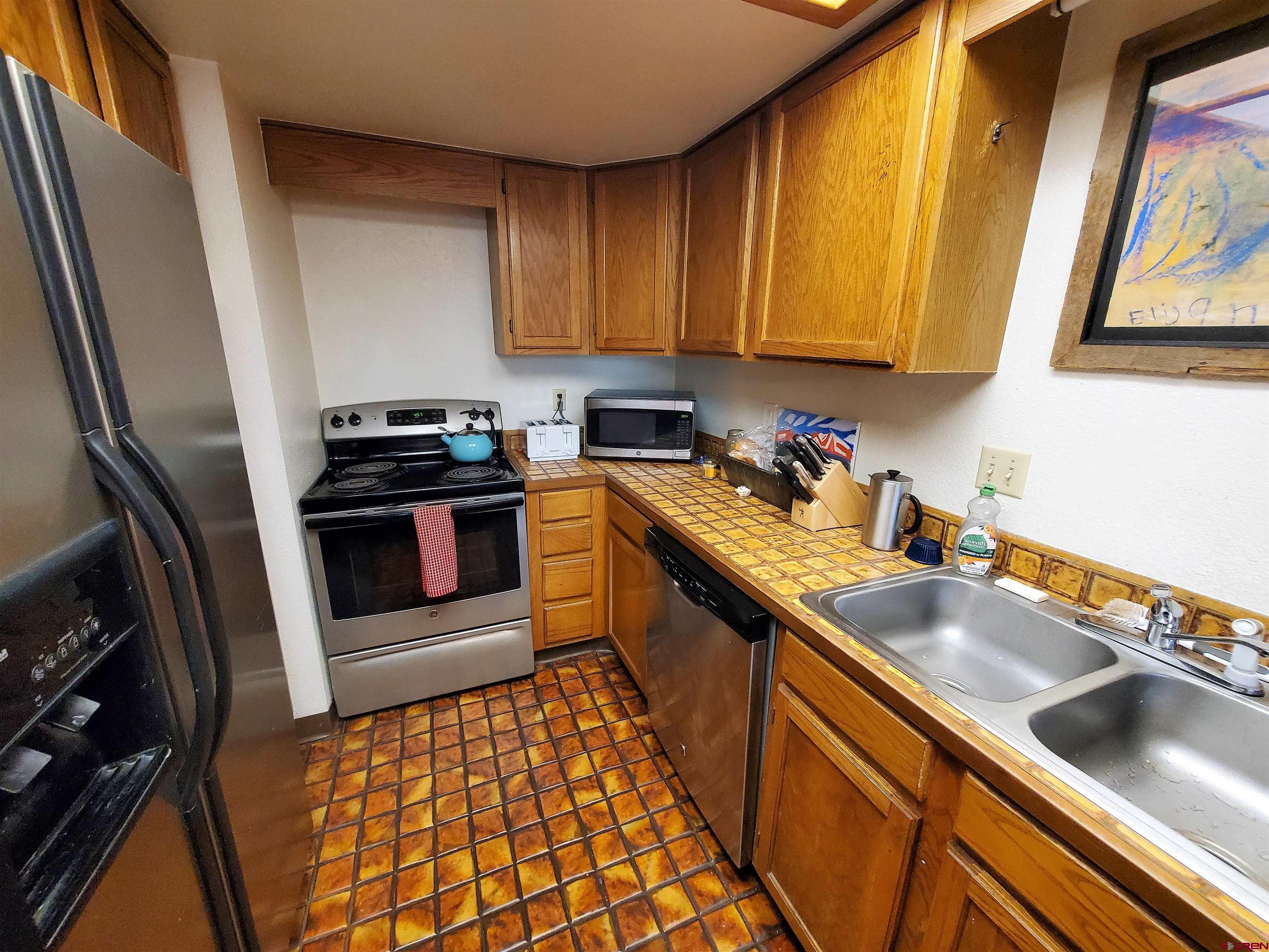 1825 Florida Road, Unit 103 Durango, CO 81301 - Photo 12 of 34 a kitchen with stainless steel appliances a sink a stove and a microwave
