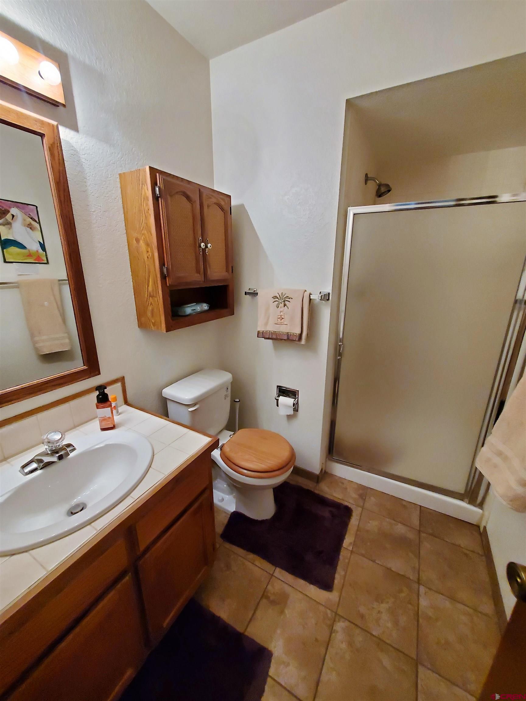 1825 Florida Road, Unit 103 Durango, CO 81301 - Photo 13 of 34 a bathroom with a granite countertop sink toilet a mirror and shower