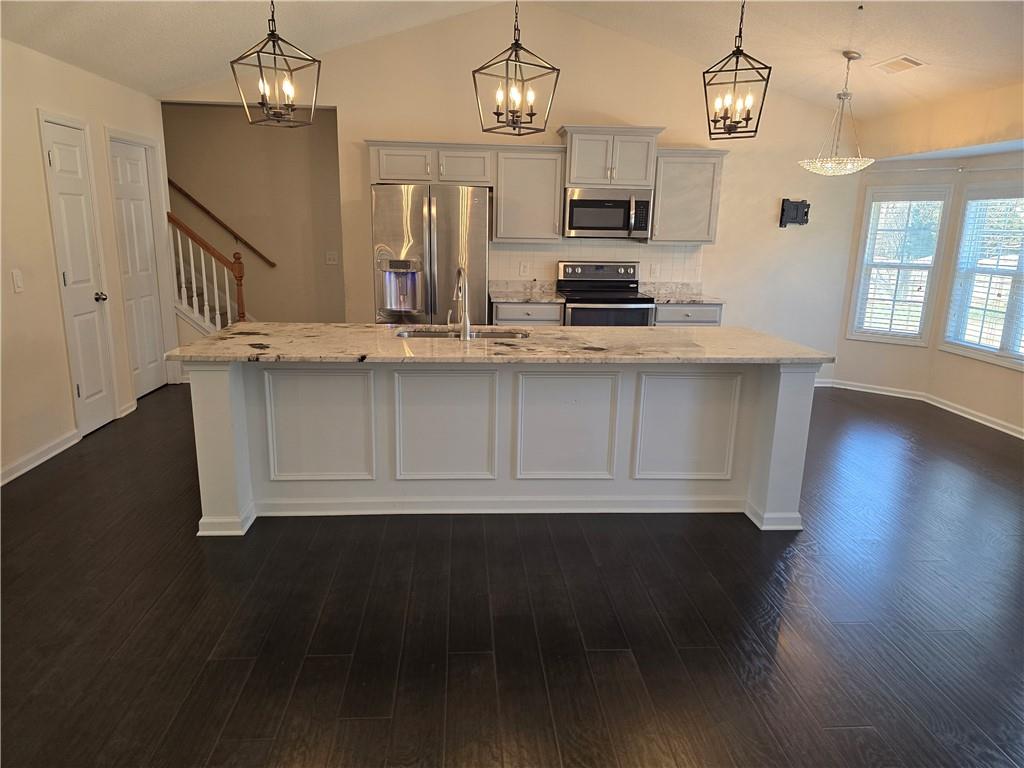 607 McDowell Lane Bethlehem, GA 30620 - Photo 8 of 22 a kitchen with stainless steel appliances a kitchen island wooden floors and a view of living room