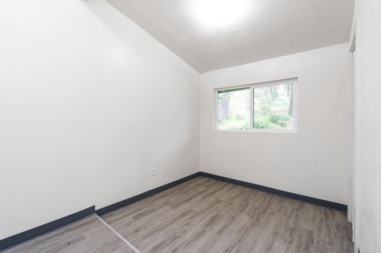 46801 Dunlap Road Miramonte, CA 93641 - Photo 12 of 28 an empty room with wooden floor and windows
