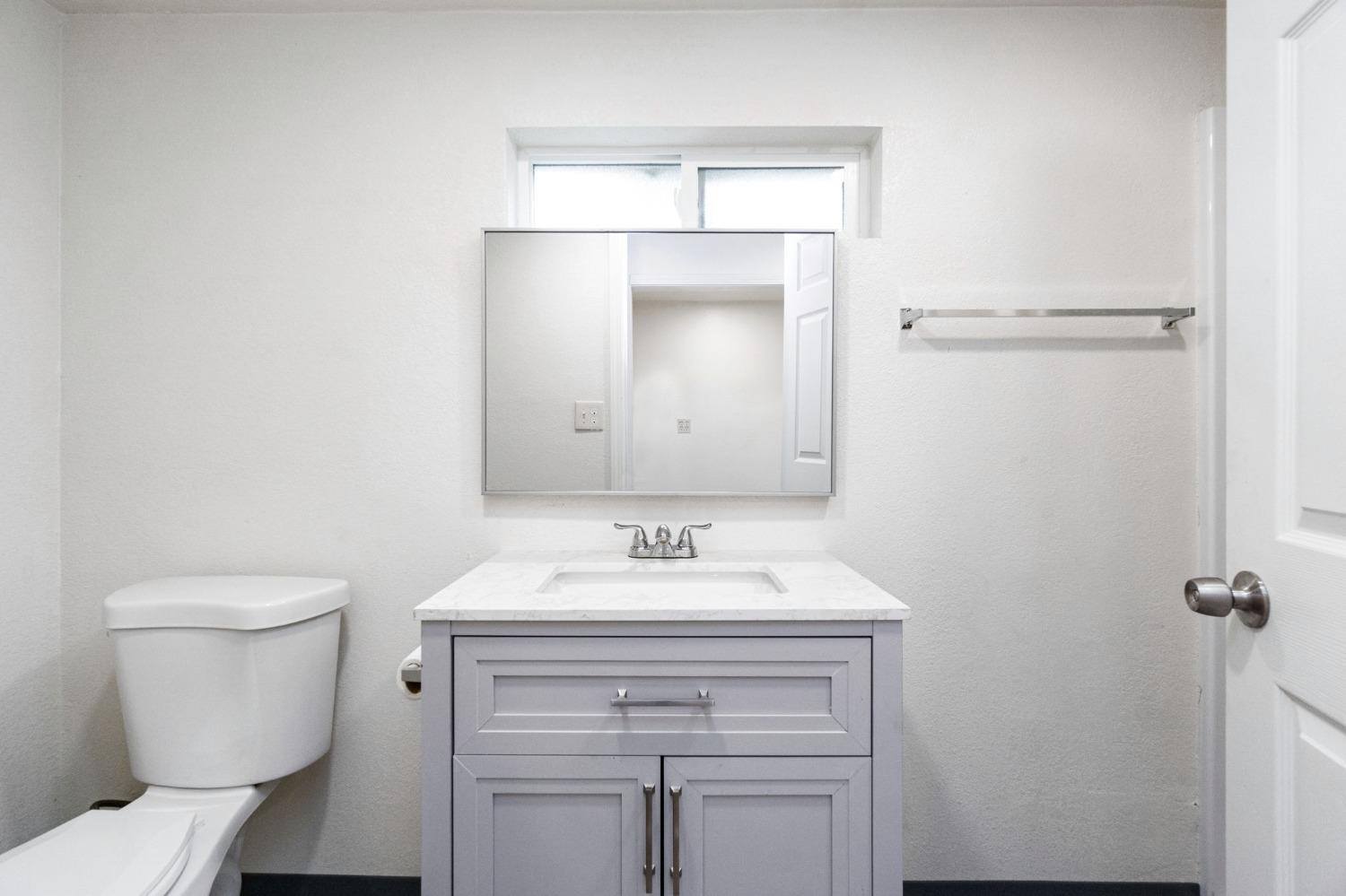 46801 Dunlap Road Miramonte, CA 93641 - Photo 15 of 28 a bathroom with a toilet sink vanity and mirror