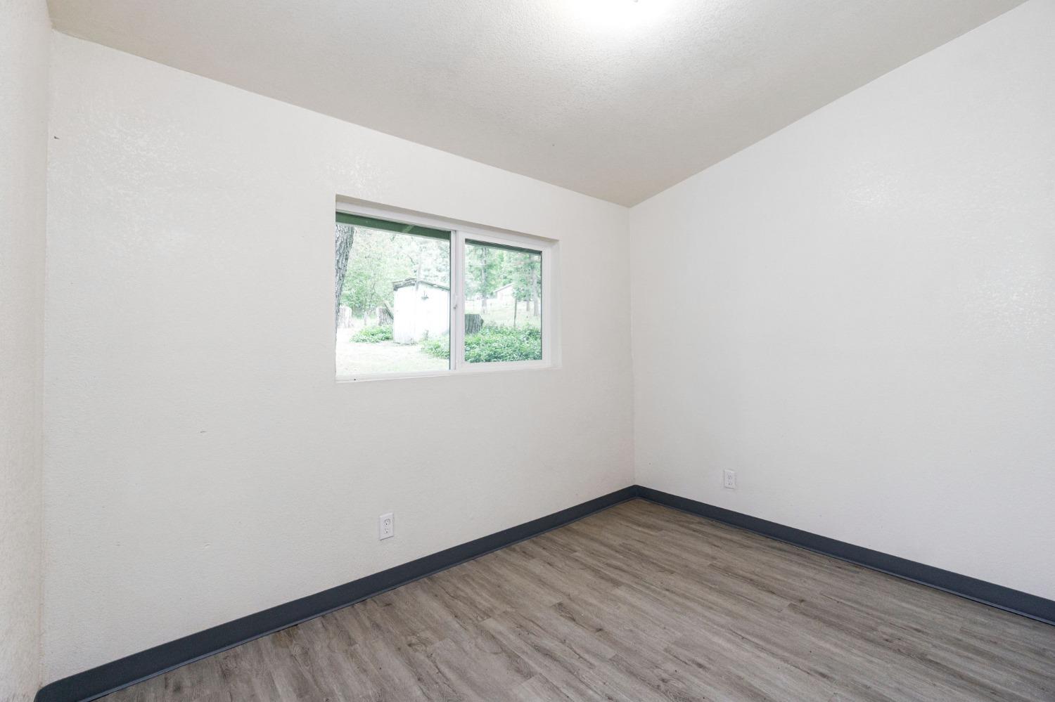 46801 Dunlap Road Miramonte, CA 93641 - Photo 10 of 28 an empty room with wooden floor and windows