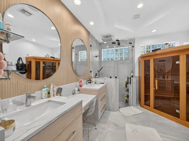 a bathroom with a double vanity sink mirror and shower