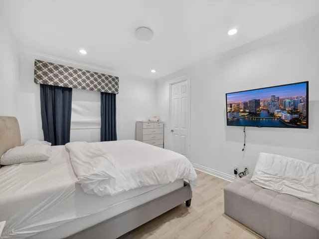 a bedroom with a bed and a flat screen tv