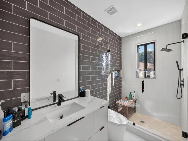 a bathroom with a sink a toilet and shower