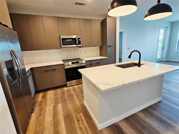 a kitchen with stainless steel appliances granite countertop a white stove top oven a sink and dishwasher