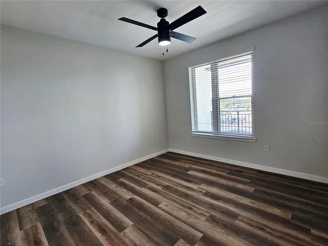 a view of a room with a window and a ceiling fan