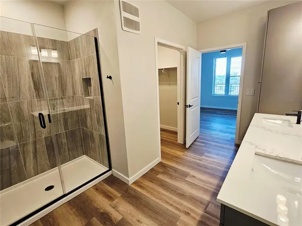 a bathroom with a glass door shower and a sink