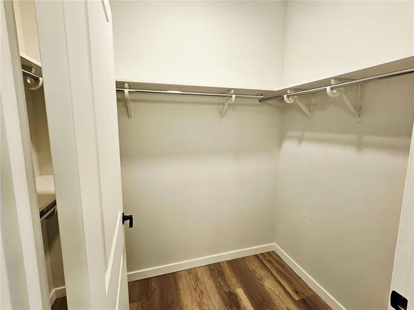 a view of walk in closet with empty racks