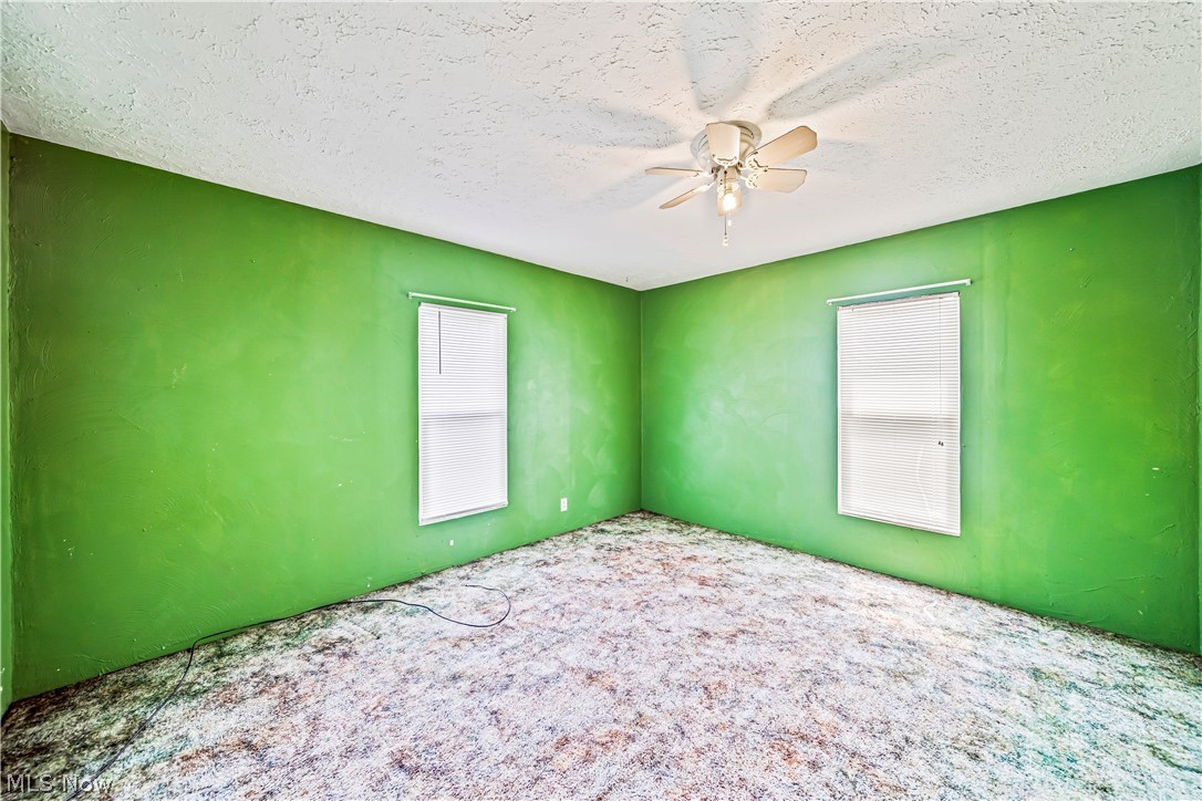 116 South Cedar Street Geneva, OH 44041 - Photo 17 of 35 Bedroom featuring carpet floors, ceiling fan, and a textured ceiling