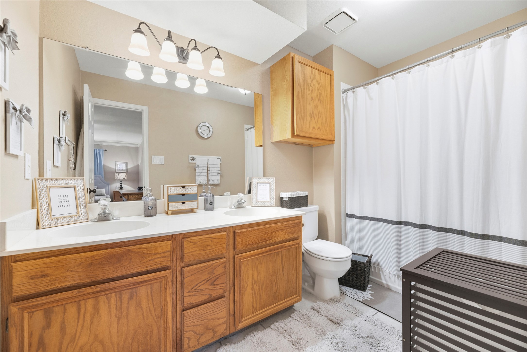 16913 Chapel Pines Drive, Unit 126 Spring, TX 77379 - Photo 21 of 27 This primary bathroom offers a spacious, well-lit vanity area with dual sinks and wooden cabinetry.