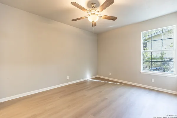 an empty room with a window and a fan