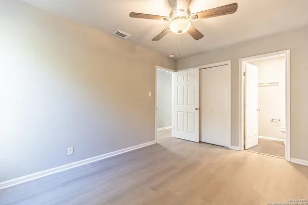an empty room with a window and a fan
