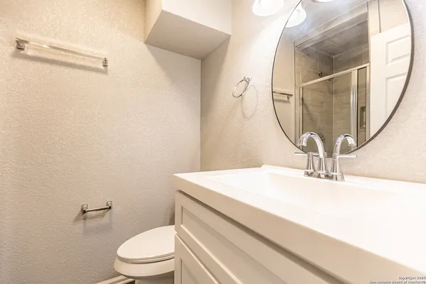 a bathroom with a sink a toilet and a mirror
