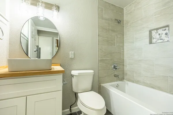 a white toilet sitting next to a bathroom sink and vanity