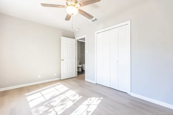 an empty room with fan and windows