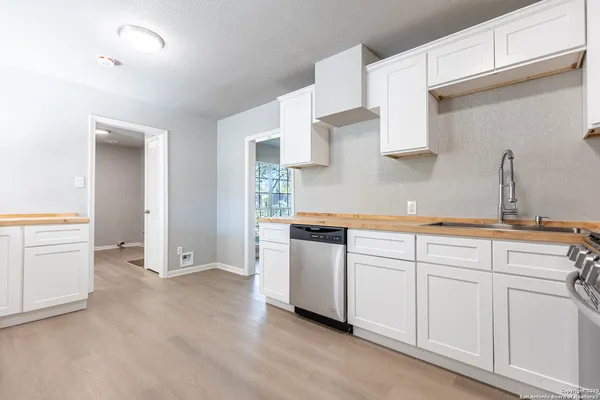 a kitchen with white cabinets and white appliances