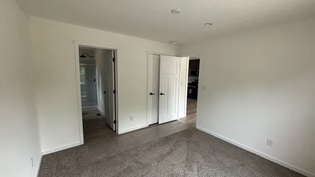 an empty room with closet and a bathroom