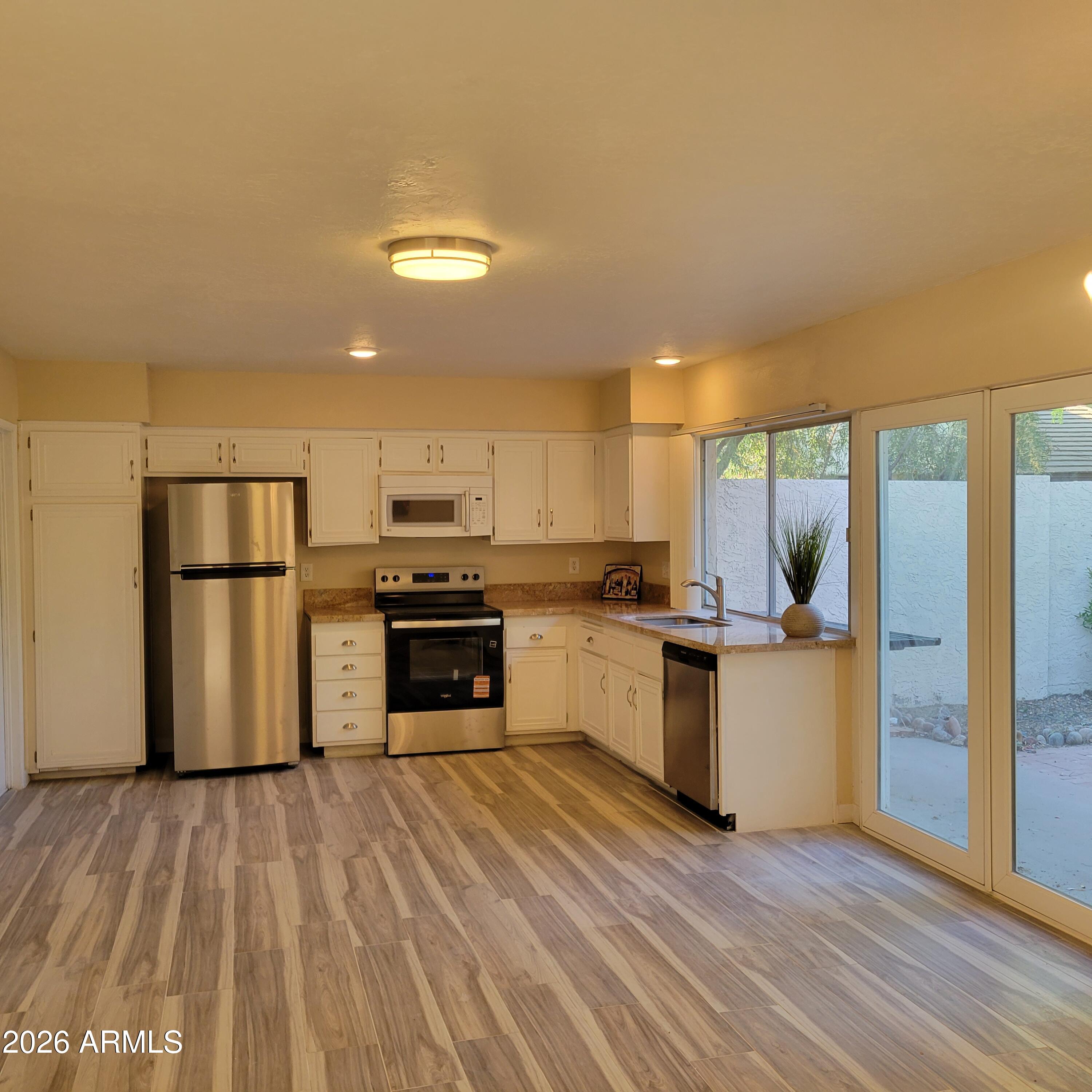 5605 South Spinnaker Road Tempe, AZ 85283 - Photo 5 of 26 a kitchen with granite countertop a refrigerator and a stove top oven