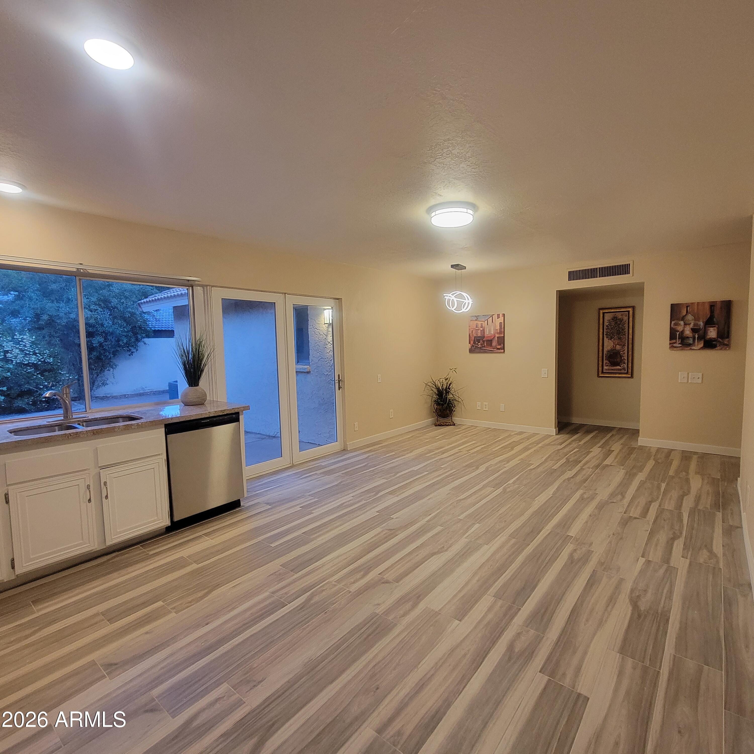 5605 South Spinnaker Road Tempe, AZ 85283 - Photo 6 of 26 a view of kitchen and empty room with wooden floor