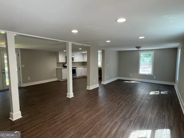 an empty room with wooden floor and window