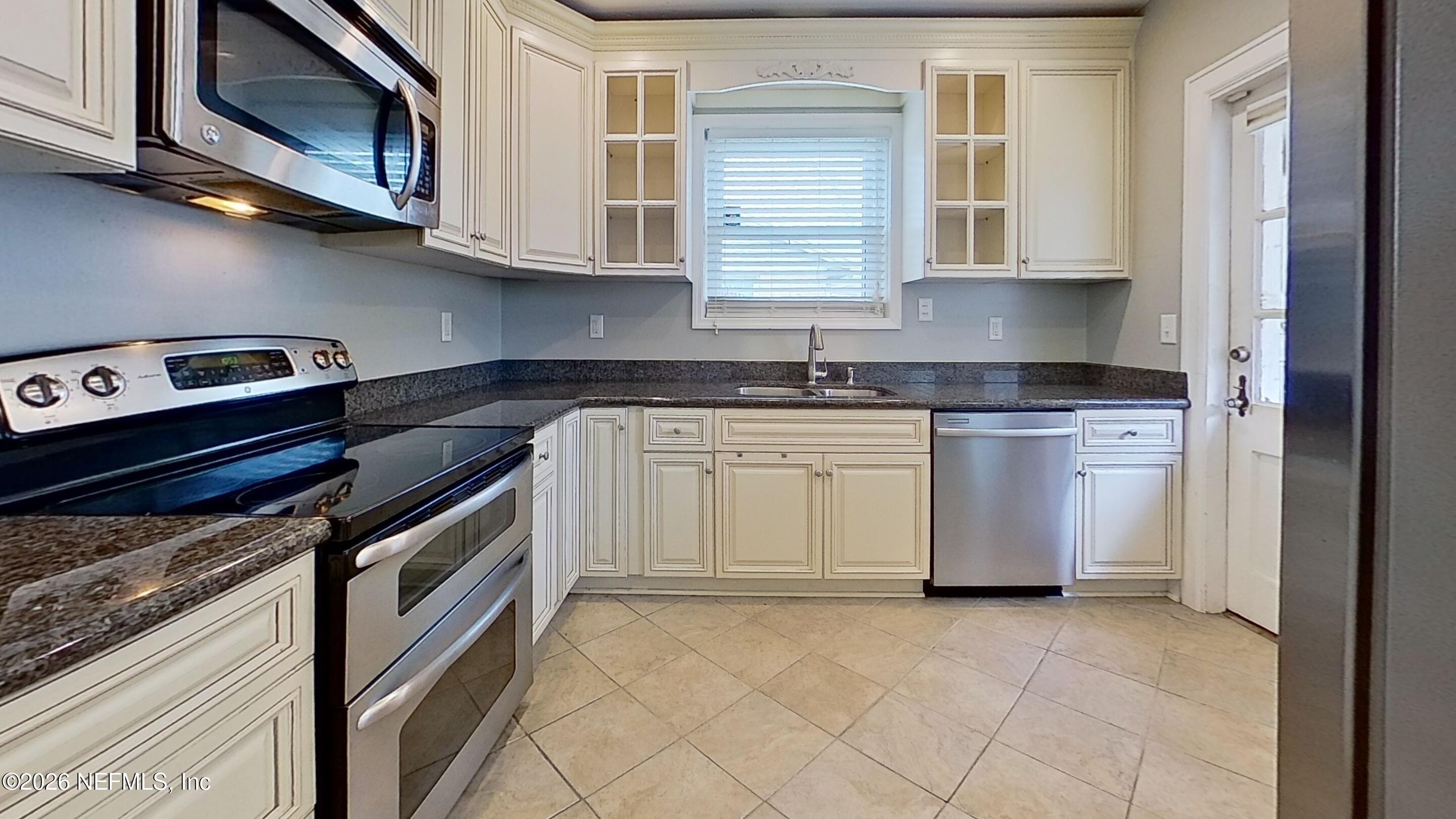 2151 Traymore Road Jacksonville, FL 32207 - Photo 9 of 18 a kitchen with stainless steel appliances granite countertop a stove a sink and a microwave