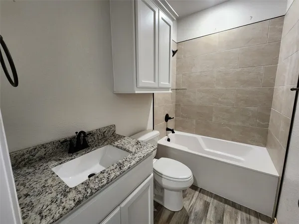 a large white kitchen with stainless steel appliances kitchen island granite countertop a refrigerator and a sink