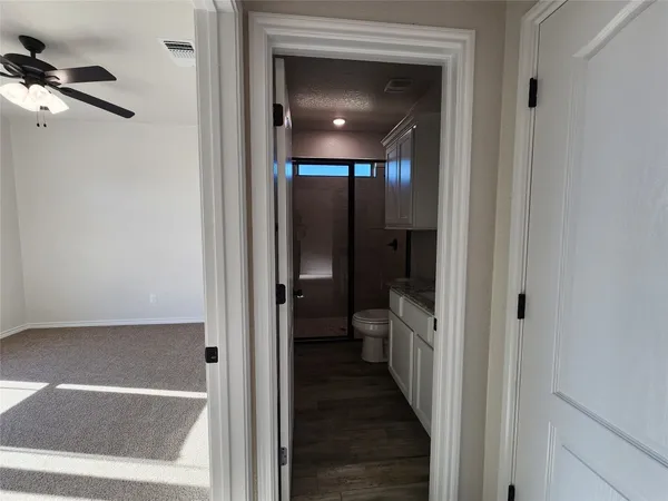a view of a hallway with a livingroom and a bathroom with bathtub