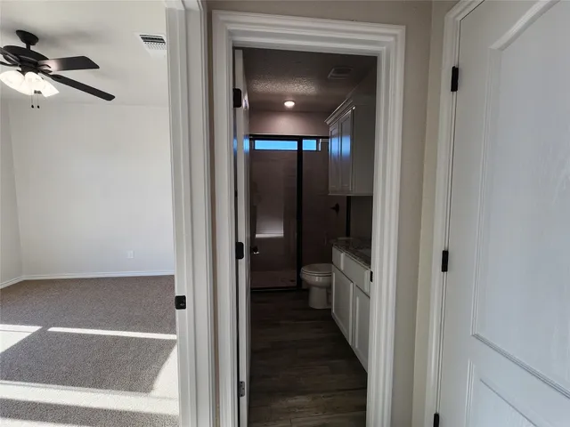 a view of a hallway with a livingroom and a bathroom with bathtub