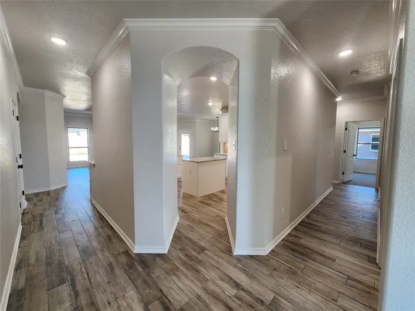 an empty room with a chandelier fan and windows