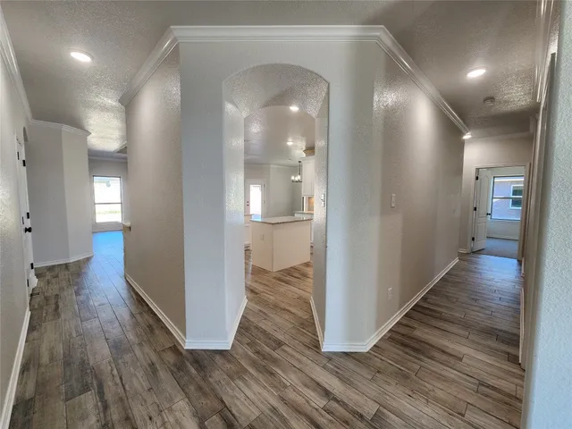 an empty room with a chandelier fan and windows