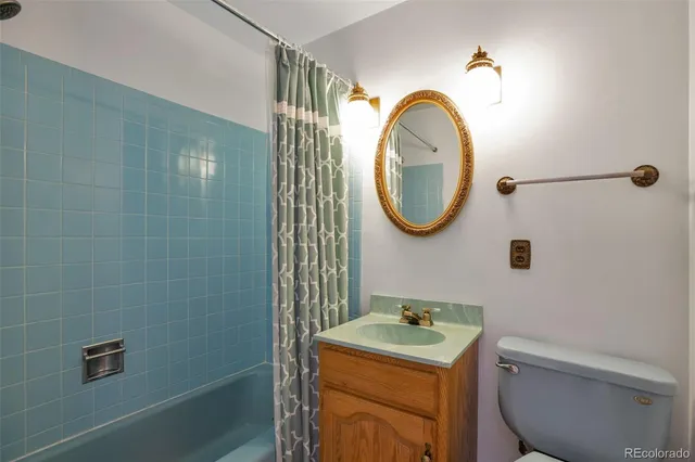 a bathroom with a toilet sink vanity and mirror